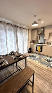 a living room with a table and a kitchen at The Bootle House in Litherland