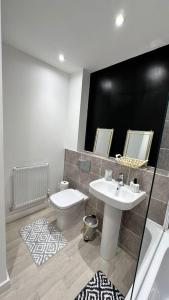 a bathroom with a sink and a toilet at The Bootle House in Litherland