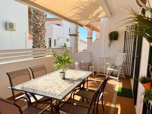 patio ze stołem i krzesłami na balkonie w obiekcie Casa El Faro w mieście El Rompido