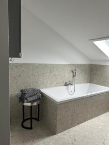 a white bath tub in a room with a stool at CASA LOBO Charmantes Ferienhaus im Allgäu in Leutkirch im Allgäu