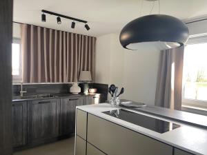 a kitchen with a sink and a black pendant light at CASA LOBO Charmantes Ferienhaus im Allgäu in Leutkirch im Allgäu