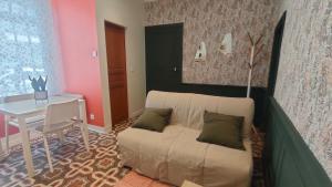 a living room with a couch and a table at Studio rénové maison de village du Luberon in Villelaure