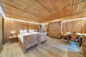 - une chambre avec un lit et un plafond en bois dans l'établissement Apartement Lanthalerhof, à San Martino