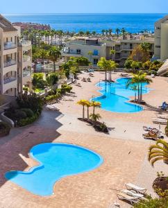 an aerial view of a resort with blue pools at Luxuriöse Duplex Ferienwohnung in sehr ruhiger Wohnanlage mit Meerblick in Palm-mar