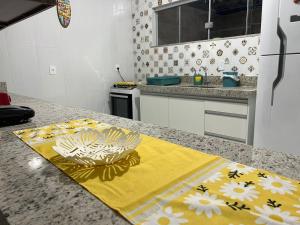 eine Küchentheke mit einer Schüssel auf einem gelben Handtuch in der Unterkunft Lindo Apê em Coroa Vermelha BA in Santa Cruz Cabrália