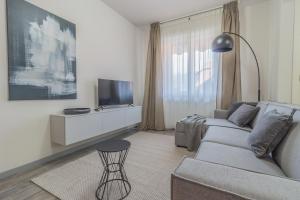 - un salon avec un canapé et une télévision dans l'établissement Casa Mimosa, à Lierna