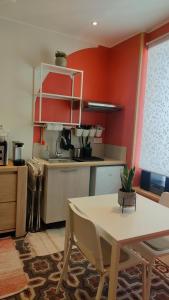 a kitchen with red walls and a table with chairs at Studio rénové maison de village du Luberon in Villelaure