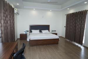 - une chambre avec un lit, un bureau et une chaise dans l'établissement Madhav Kuteer B- 34 Vrindavan, à Vrindavan