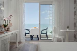 een slaapkamer met een kamer met uitzicht op de oceaan bij Hotel Mediterraneo in Riccione