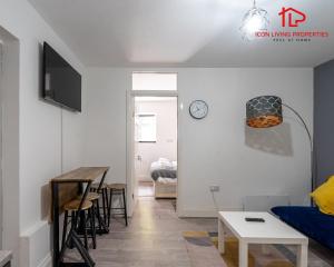 a living room with a table and a dining room at Arch-View Apartment 1 By Icon Living Properties Short Lets & Serviced Accommodation Wembley in London