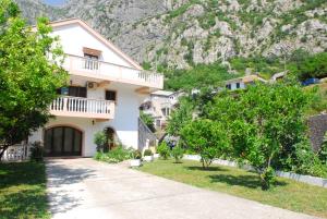 a house with a mountain in the background at Apartments Blue Lagoon in Kotor