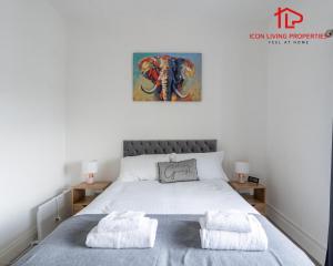 ロンドンにある1 Bedroom Arch-View Apartment 2 By Icon Living Properties Short Lets & Serviced Accommodation With Free Parkingのベッドとタオル2枚のある寝室