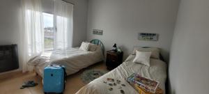 1 dormitorio con 2 camas y ventana en Marina El Condor en Balneario El Cóndor