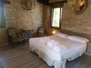 1 dormitorio con 1 cama con toallas en Segarati Relax La Romantica, en Rocca di Varsi