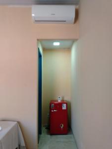 a room with a red suitcase in a hallway at Pousada Pérola do Rio in Barreirinhas