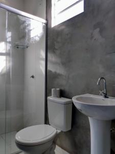 a bathroom with a toilet and a sink and a shower at Pousada Pérola do Rio in Barreirinhas