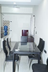 - une table à manger noire avec des chaises noires dans l'établissement Madhav Kuteer B- 34 Vrindavan, à Vrindavan