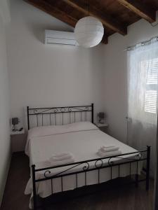 een slaapkamer met een wit bed met een zwart frame bij Teo’s Holiday Home in Canino