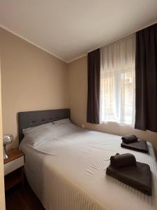 een slaapkamer met een groot wit bed en een raam bij Stefan Suite Belgrade Center Apartment in Belgrado