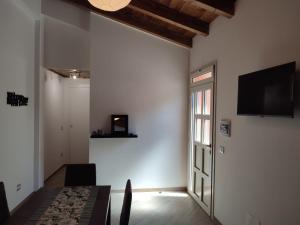 a dining room with a table and a television on a wall at Teo’s Holiday Home in Canino