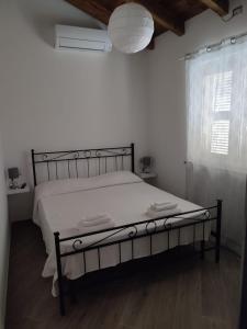 een slaapkamer met een bed in een witte kamer bij Teo’s Holiday Home in Canino