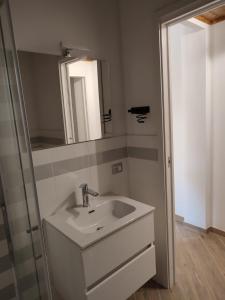 een badkamer met een wastafel en een spiegel bij Teo’s Holiday Home in Canino