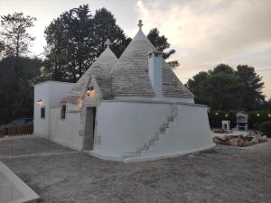 un piccolo edificio bianco con un tetto con una scala di L'Humus dei Trulli holiday house a Martina Franca