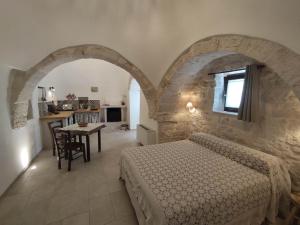 una camera da letto con un letto e un tavolo in una stanza di L'Humus dei Trulli holiday house a Martina Franca