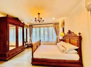 ein Schlafzimmer mit einem großen Bett und einem Kronleuchter in der Unterkunft Cozy house with 3 big bedrooms in Ban Suan