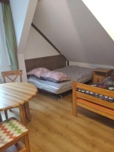 mały pokój z łóżkiem i stołem w obiekcie LEŚNA OSADA w mieście Tuchlin