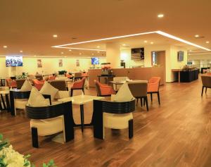 Skylight In-Terminal Hotel في أديس أبابا: مطعم فيه طاولات وكراسي في الغرفة