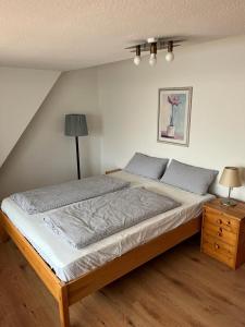 - une chambre avec un grand lit et une table de nuit dans l'établissement Nord Haus, à Kiel