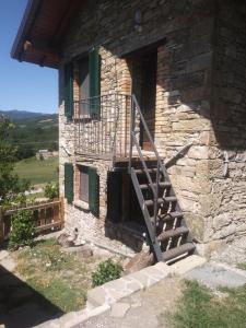 Edificio de piedra con escalera y balcón en Segarati Relax La Romantica, en Rocca di Varsi