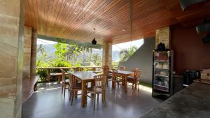 ein Esszimmer mit Holzdecken sowie einem Tisch und Stühlen in der Unterkunft Puri Jumpungan Villas in Sidemen