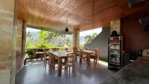 a dining room with wooden ceilings and a table and chairs at Puri Jumpungan Villas in Sidemen