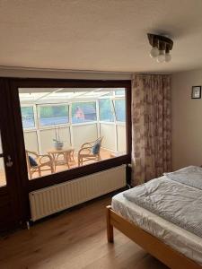 Schlafzimmer mit einem Balkon mit einem Tisch und Stühlen in der Unterkunft Nord Haus in Kiel