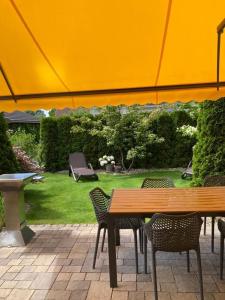 un patio con mesa, sillas y sombrilla en Sommergarten 33, en Ostseebad Karlshagen