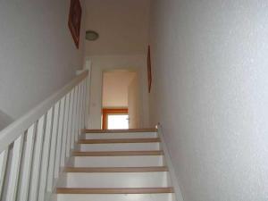 una escalera en una casa con escaleras blancas y una ventana en Sommergarten 33, en Ostseebad Karlshagen