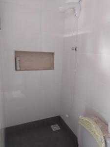 um chuveiro num quarto branco com uma janela em Casa de Praia em Balneário Gaivotas