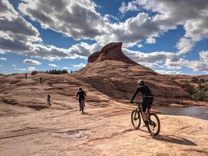 dos personas montando bicicletas en un camino de tierra en Sage Creek at Moab Luxury Combo D en Moab