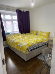 a bedroom with a bed and a purple curtain at Charming 2-Bed Apartment in Heathrow first floor in Hayes