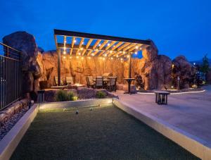 un patio con mesa, sillas y pared de piedra. en Sage Creek at Moab Luxury Combo D en Moab