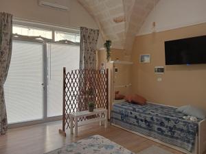 1 dormitorio con 1 cama y TV en una habitación en Casina Al Maestrale en San Pancrazio Salentino