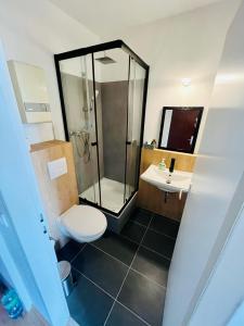 a bathroom with a shower and a toilet and a sink at NaSa Wohnen Zentrum in Krefeld
