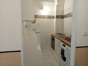 a kitchen with a washing machine and a sink at Casina Al Maestrale in San Pancrazio Salentino +2 photos