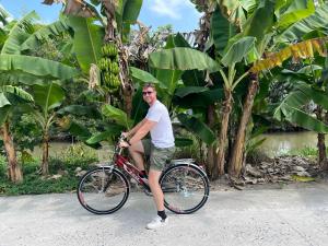 a man riding a bike in front of a bunch of bananas at WELKOM INN in Can Tho