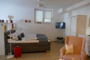 a bedroom with a bed and a tv and a chair at Apartment Am Markt 13 in Konz