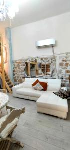 - un salon avec des canapés blancs et un mur en pierre dans l'établissement La tana dei Draghi, à Formia