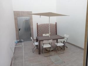a black table and chairs with an umbrella at Casina Al Maestrale in San Pancrazio Salentino