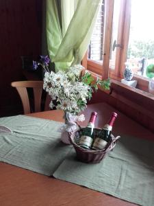 a basket of wine bottles and flowers on a table at Haus Babajaga in Allrode